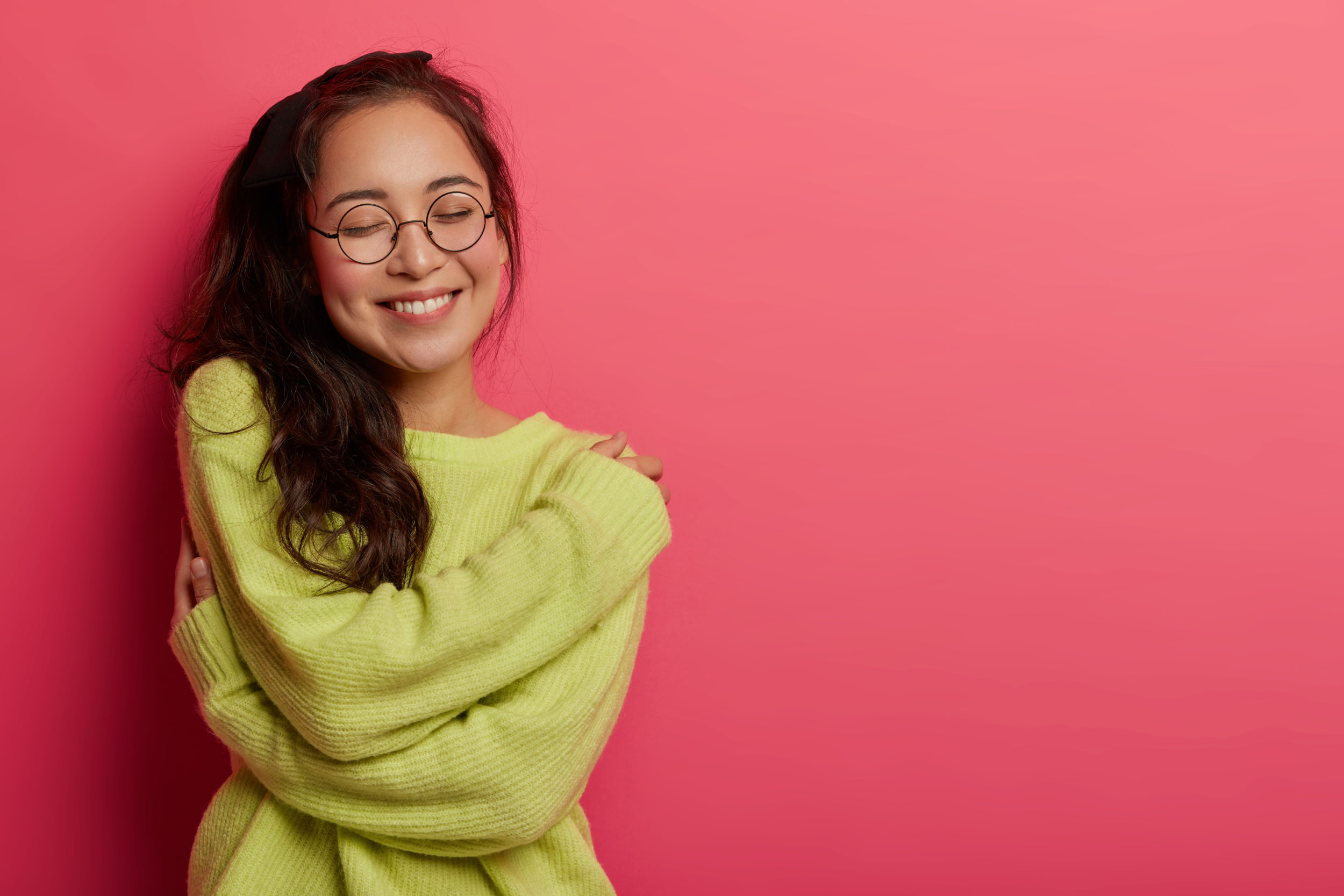 Photo Of Charming Woman Expresses Self Love And Care, Enjoys Wearing New Soft Green Sweater, Embraces Own Body, Recalls Romantic Moment With Boyfriend, Smiles Pleasantly, Stands Over Rosy Wall Photo Of Charming Woman Expresses Self Love And Care, Enjoys Wearing New Soft Green Sweater, Embraces Own Body, Recalls Romantic Moment With Boyfriend, Smiles Pleasantly, Stands Over Rosy Wall
